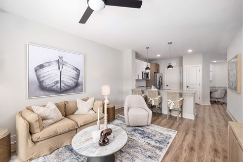 A living room with a couch, a coffee table, and a painting of a ship on the wall.