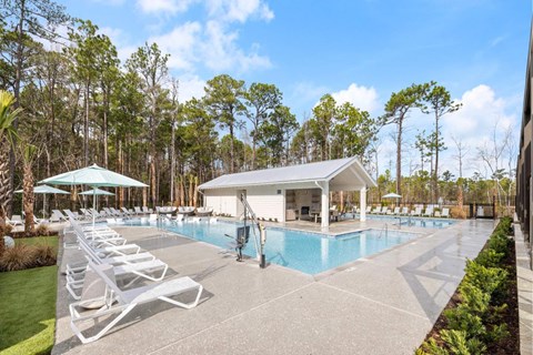 A pool area with sun loungers and a pavilion.