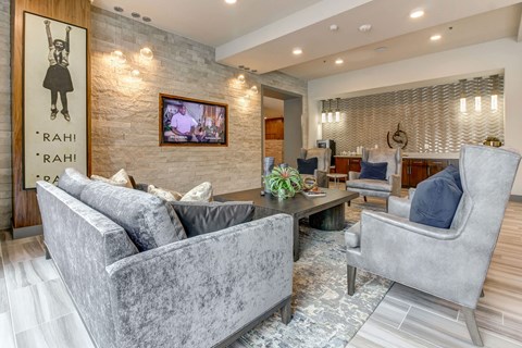 A living room with grey couches and a TV mounted on the wall.