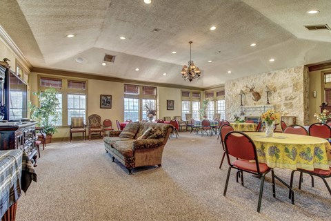 A living room with a stone wall and a dining table set for six.