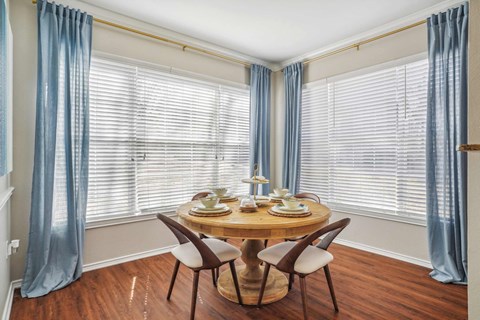 A dining room with a round table and chairs.