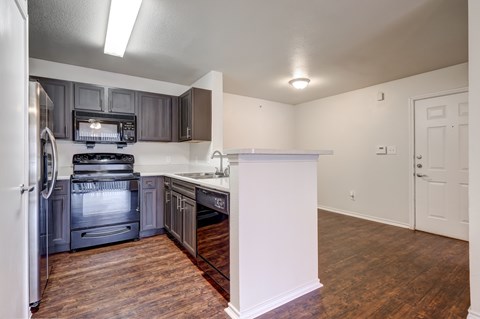 A kitchen with a white refrigerator and a black stove top oven.