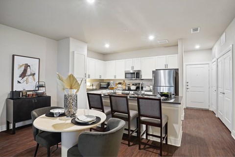 A modern kitchen with a dining table set for four.