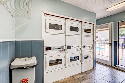 A row of white ovens are lined up in a kitchen.