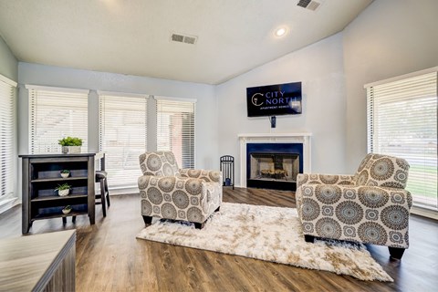 A living room with a fireplace and two chairs.