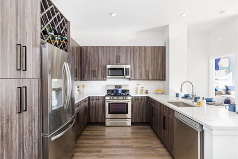 A modern kitchen with wooden cabinets and stainless steel appliances.