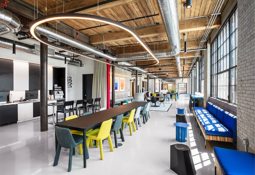 A modern cafeteria with a long table and chairs.