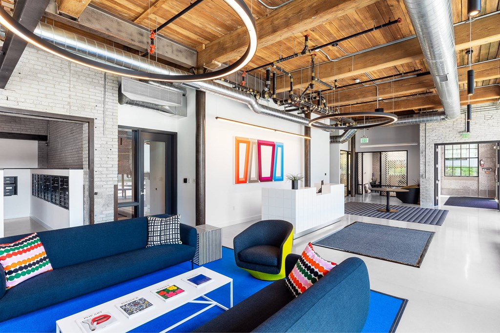A modern living room with a blue couch and a white coffee table.