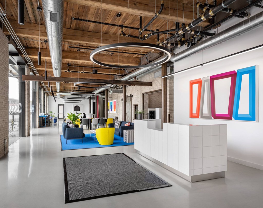 A reception area with a white reception desk and a grey rug.