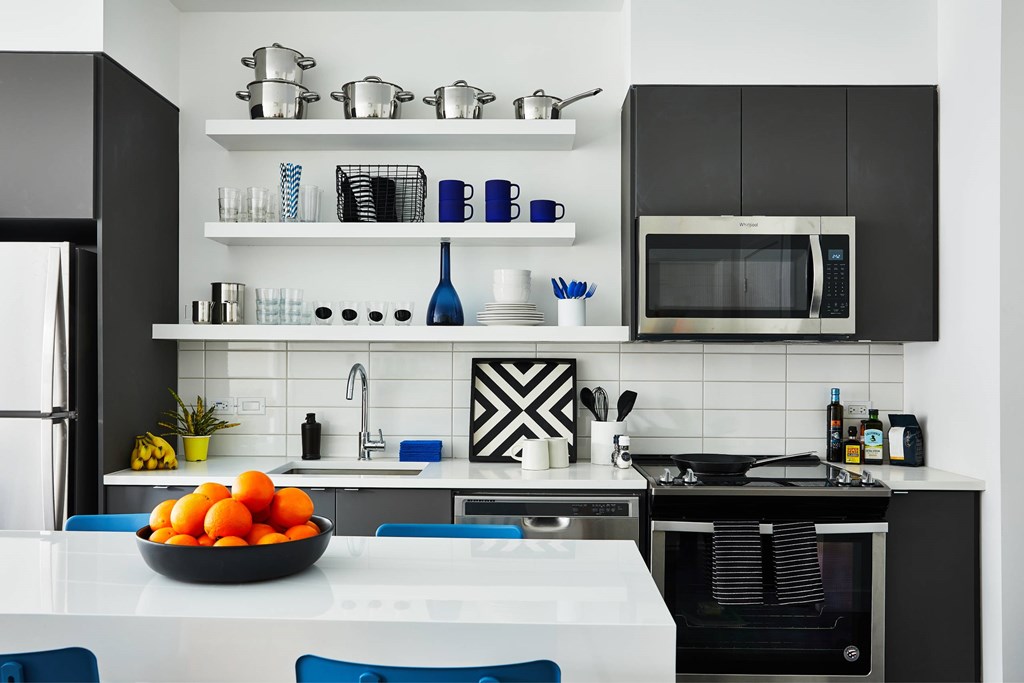 A kitchen with black cabinets and a white countertop.