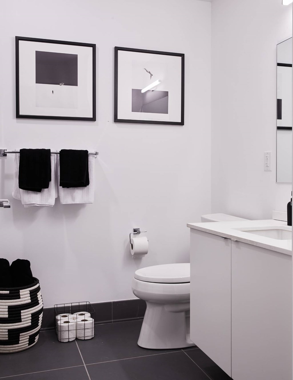 A bathroom with a toilet, sink, and towels.