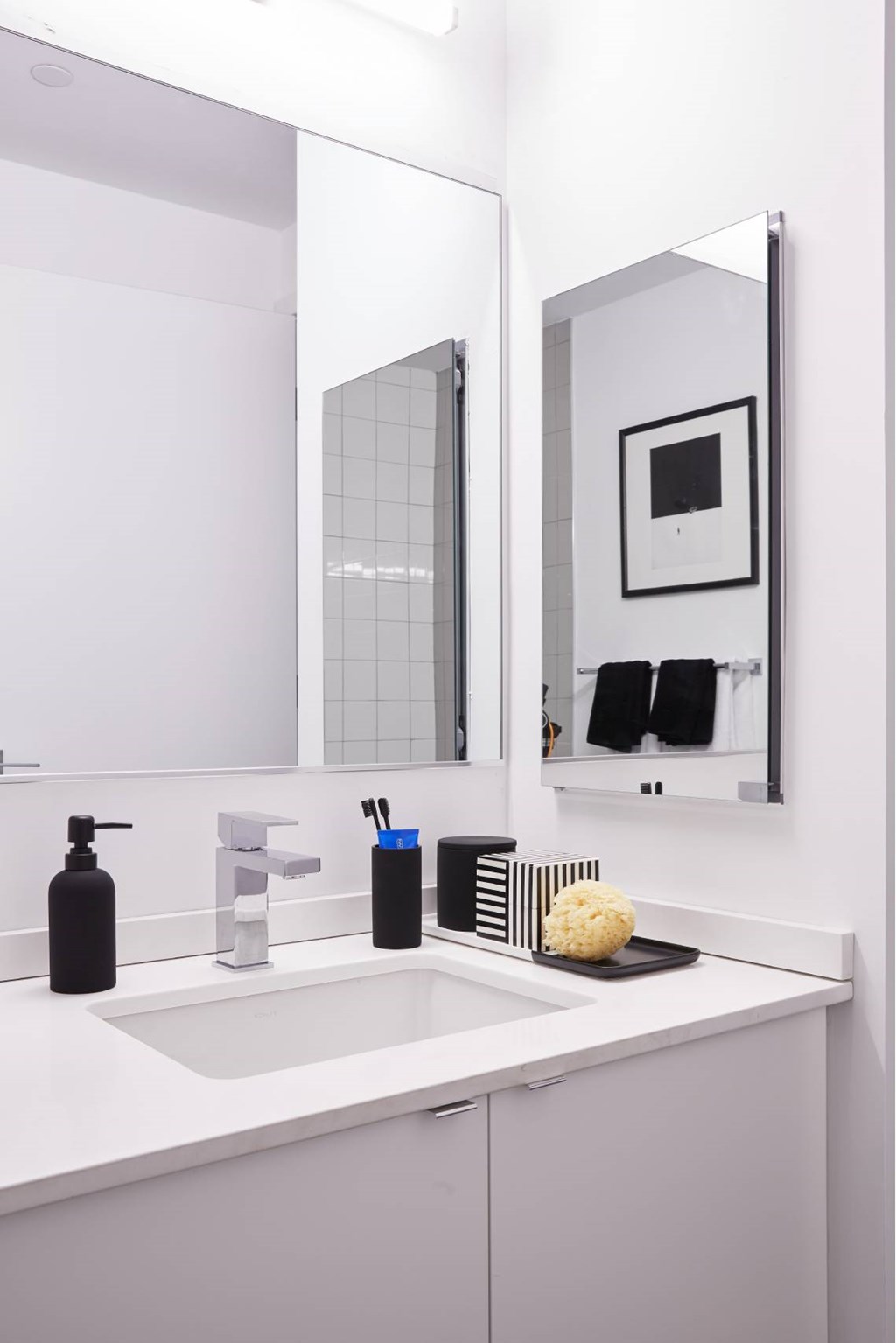 A bathroom with a white sink and a mirror above it.