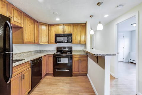 A kitchen with wooden cabinets and black appliances.