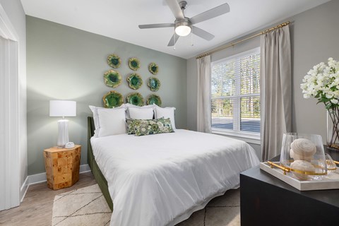 A bedroom with a white bed and green accents.
