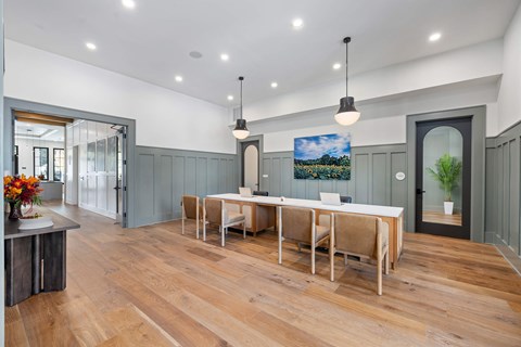 A dining room with a long table and chairs.
