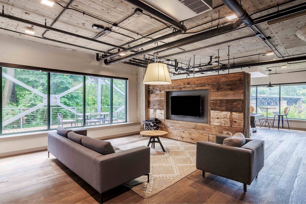 A modern living room with a flat screen TV mounted on a wooden wall.