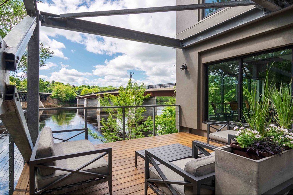 A patio with a table and chairs overlooking a river.