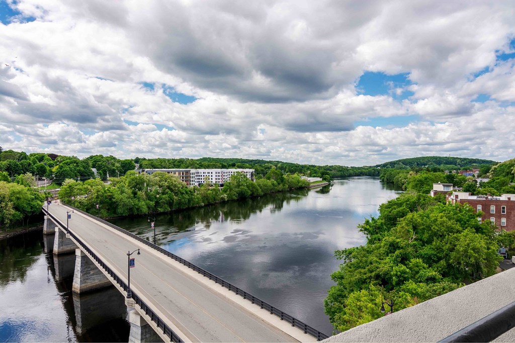 A bridge over a river with a cloudy sky above.