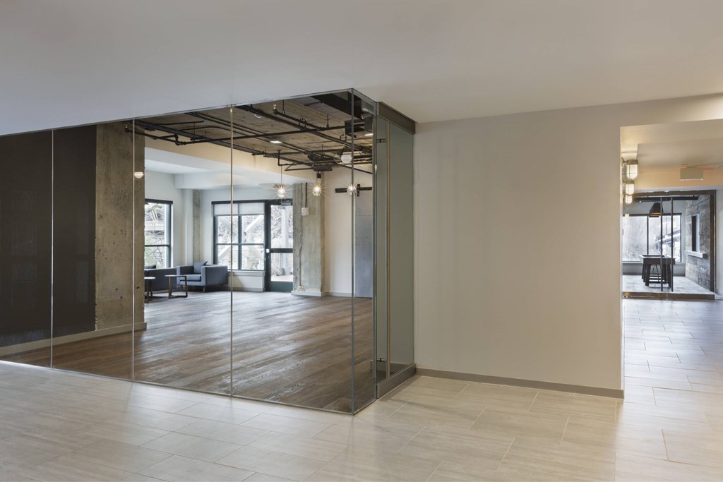 A modern office space with glass walls and wooden floors.