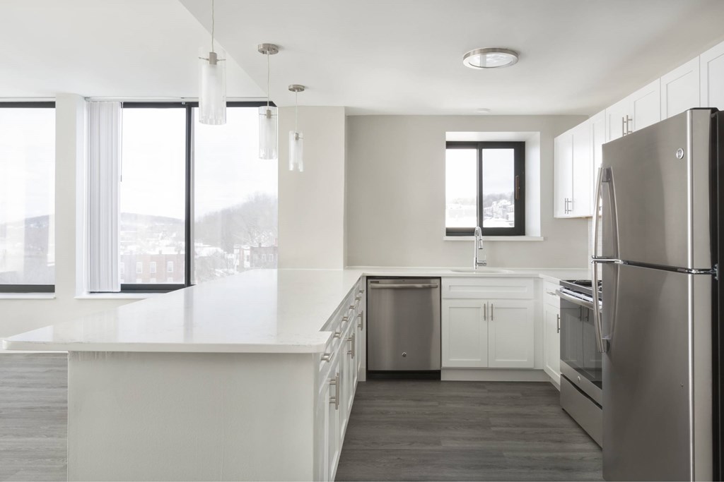 A modern kitchen with stainless steel appliances and white cabinetry.