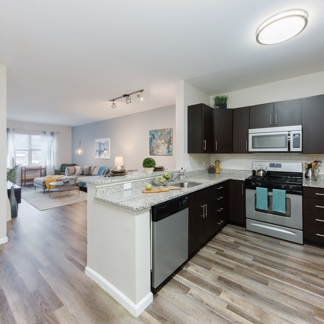 A modern kitchen with dark wood cabinets and a white island.
