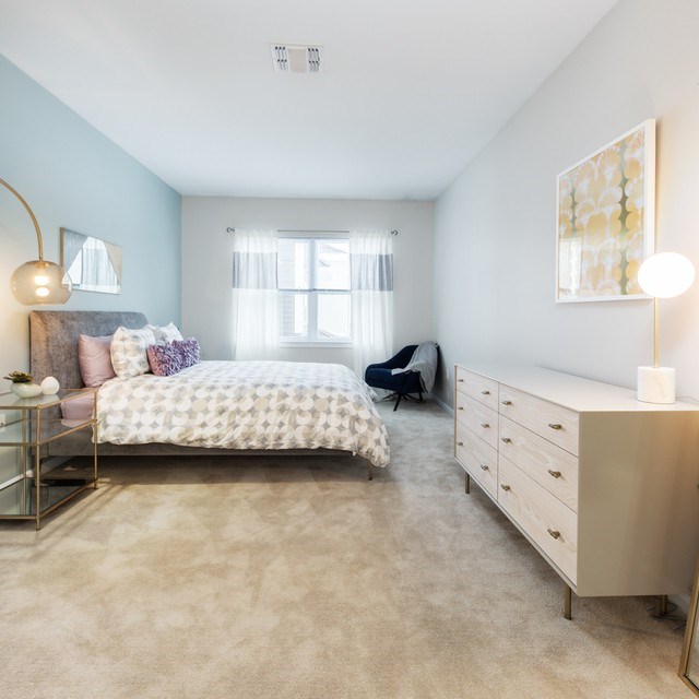 A bedroom with a bed, chair, and a desk.