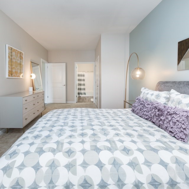 A bedroom with a large bed and a dresser.