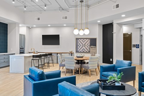 A modern living room with blue chairs and a television.