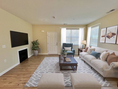 A living room with a couch, chair, and fireplace.