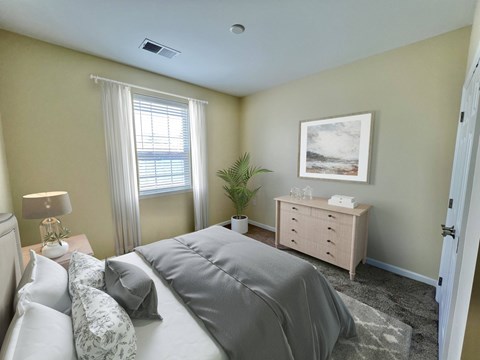 Garden-Style Apartments Near Lehigh Valley Mall in Northampton, PA - Residences at Willow Ridge - A Bedroom with Carpet Flooring, and a Nightstand with a Lamp.
