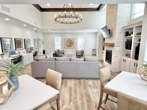A modern living room with a grey sofa and a wooden dining table.