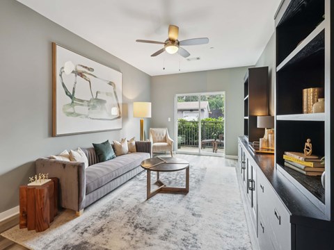 A living room with a grey couch, a coffee table, and a painting on the wall.