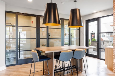 A modern dining room with a wooden table and grey chairs.