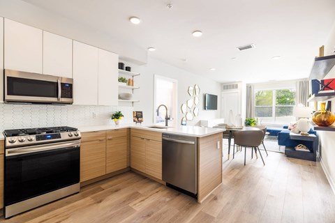 A modern kitchen with wooden cabinets and a stainless steel oven.