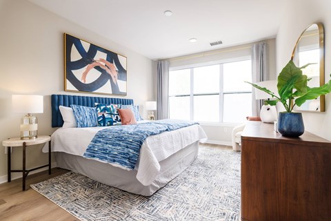 A bedroom with a large bed and a painting on the wall.