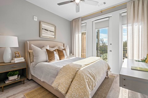 A bedroom with a large bed and a ceiling fan.