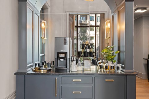 A modern kitchen with a dark grey cabinet and a coffee machine on the counter.