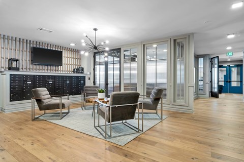 A modern living room with a wooden floor and a television on the wall.