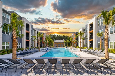 Exterior view of The Ames apartment community pool and buildings