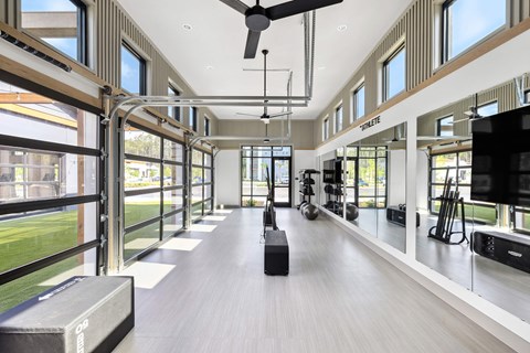 A spacious room with a long hallway and a ceiling fan.