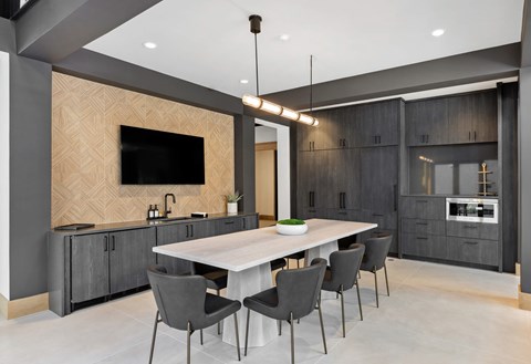A modern dining room with a large table and chairs.