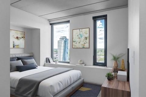 A bedroom with a large bed and a window overlooking a cityscape.
