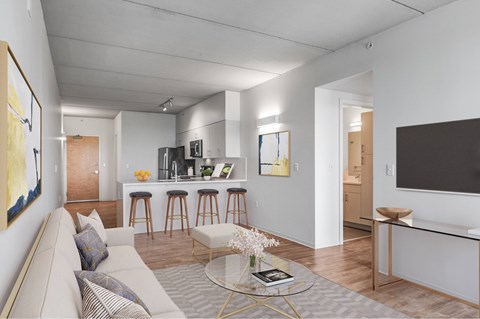 A modern living room with a grey sofa and a glass coffee table.