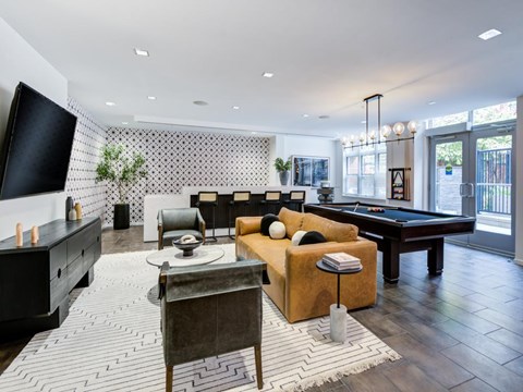 A living room with a pool table and a television.