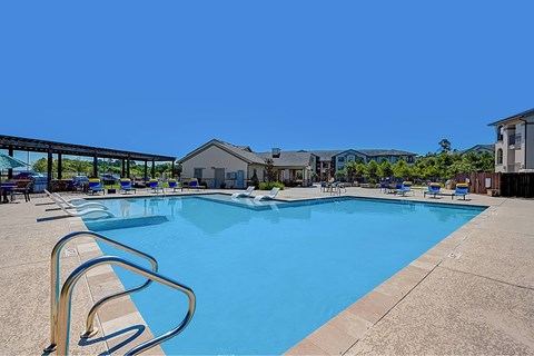 A large swimming pool with a metal ladder on the side.