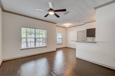 A room with a ceiling fan and wooden flooring.