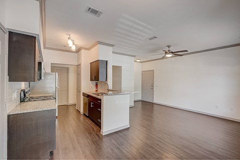 A kitchen with a refrigerator, microwave, and a counter with a sink.