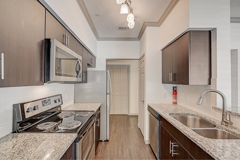 A kitchen with a stove top oven and microwave above it.