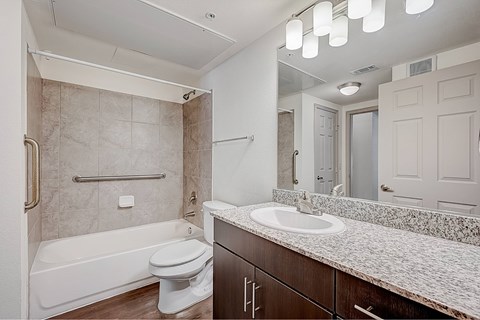 A bathroom with a white toilet, a bathtub, and a sink.