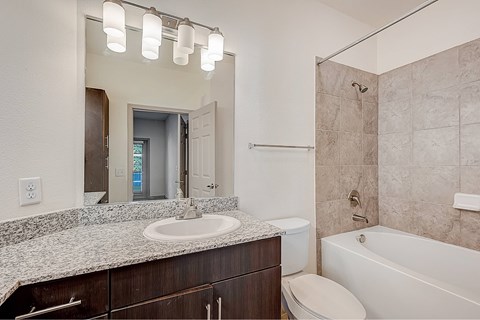 A bathroom with a sink, toilet, and bathtub.